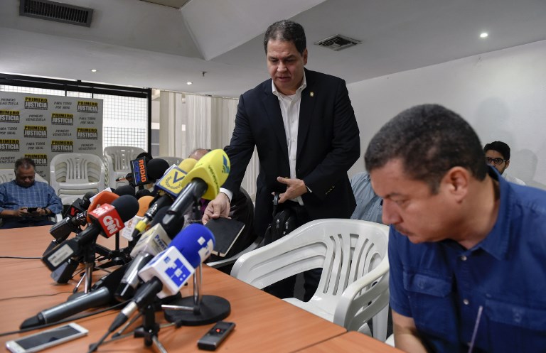 Opposition lawmaker Luis Florido (C) gets ready to take part in a press conference in Caracas on December 4, 2017.  Opposition representatives in the negotiations with the government of Nicolas Maduro asked for "patience" to seal agreements, although they emphasized "the urgency" to provide solutions for the shortage of foods and medicines in Venezuela. / AFP PHOTO / JUAN BARRETO