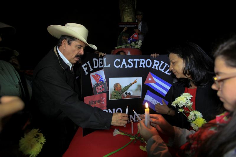 El expresidente de Honduras Manuel Zelaya enciende una vela junto a una imagen del fallecido líder cubano Fidel Castro en la Plaza Cuba en Tegucigalpa, Honduras