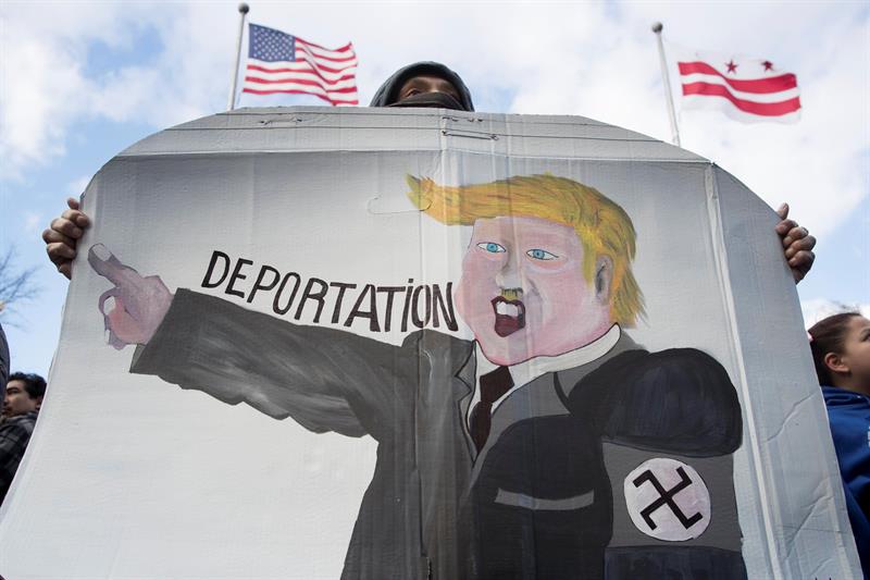 Un manifestante sostiene un dibujo en el que se representa al presidente estadounidense Donald Trump usando un brazalete de esvástica, durante una marcha realizada en apoyo al evento "Un Día Sin Inmigrantes" en Washington, DC (EE.UU.). EFE