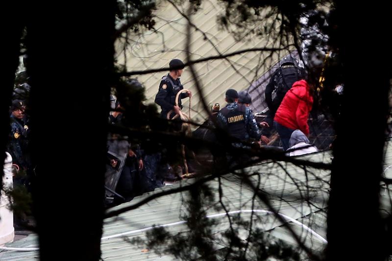 Oficiales de policía trabajan en el operativo de rescate de los monitores retenidos en un centro correccional de menores hoy, lunes 20 de marzo de 2017, en San José Pinula (Guatemala). EFE