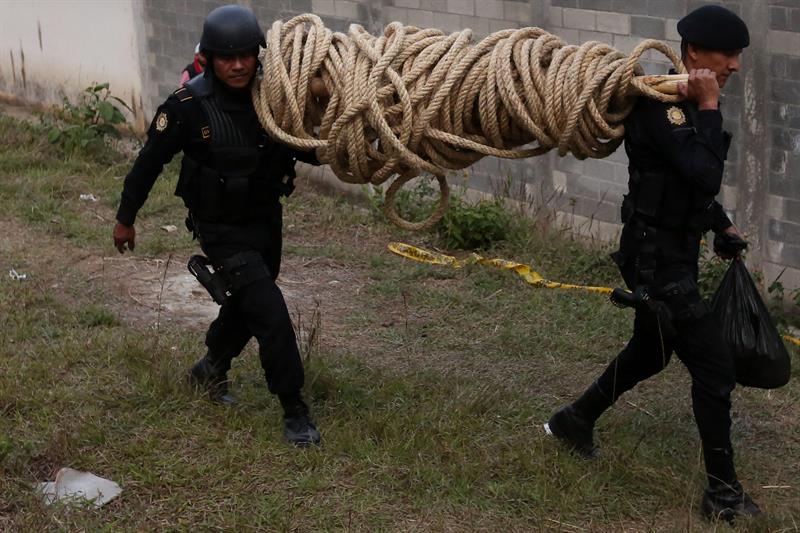 Oficiales de policía trabajan en el operativo de rescate de los monitores retenidos en un centro correccional de menores hoy, lunes 20 de marzo de 2017, en San José Pinula (Guatemala). EFE