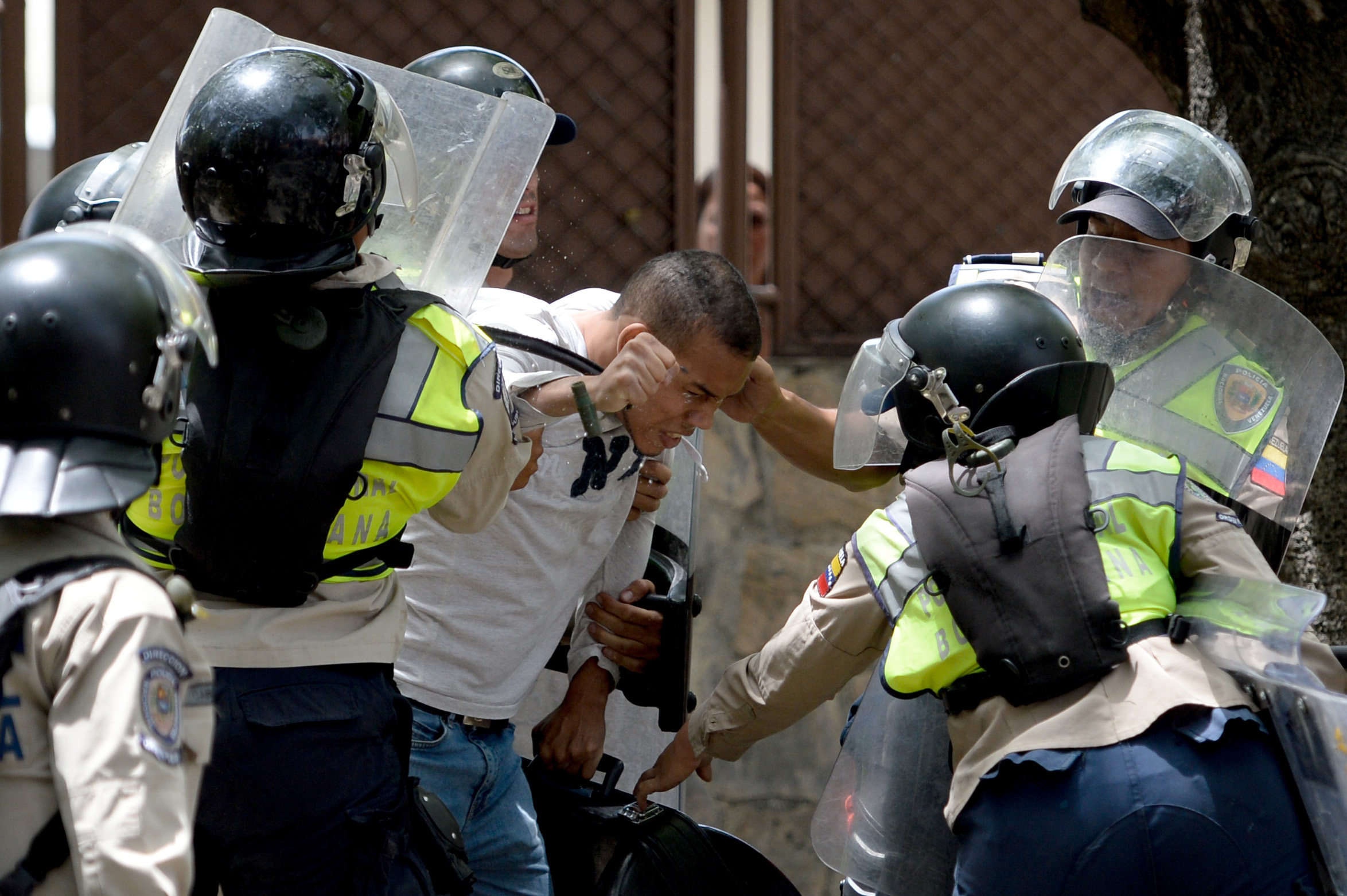 An opposition activist is arrested by riot police during a protest against President Nicolas Maduro's government in Caracas on April 4, 2017. Activists clashed with police in Venezuela Tuesday as the opposition mobilized against moves to tighten President Nicolas Maduro's grip on power. Protesters hurled stones at riot police who fired tear gas as they blocked the demonstrators from advancing through central Caracas, where pro-government activists were also planning to march. / AFP PHOTO / FEDERICO PARRA