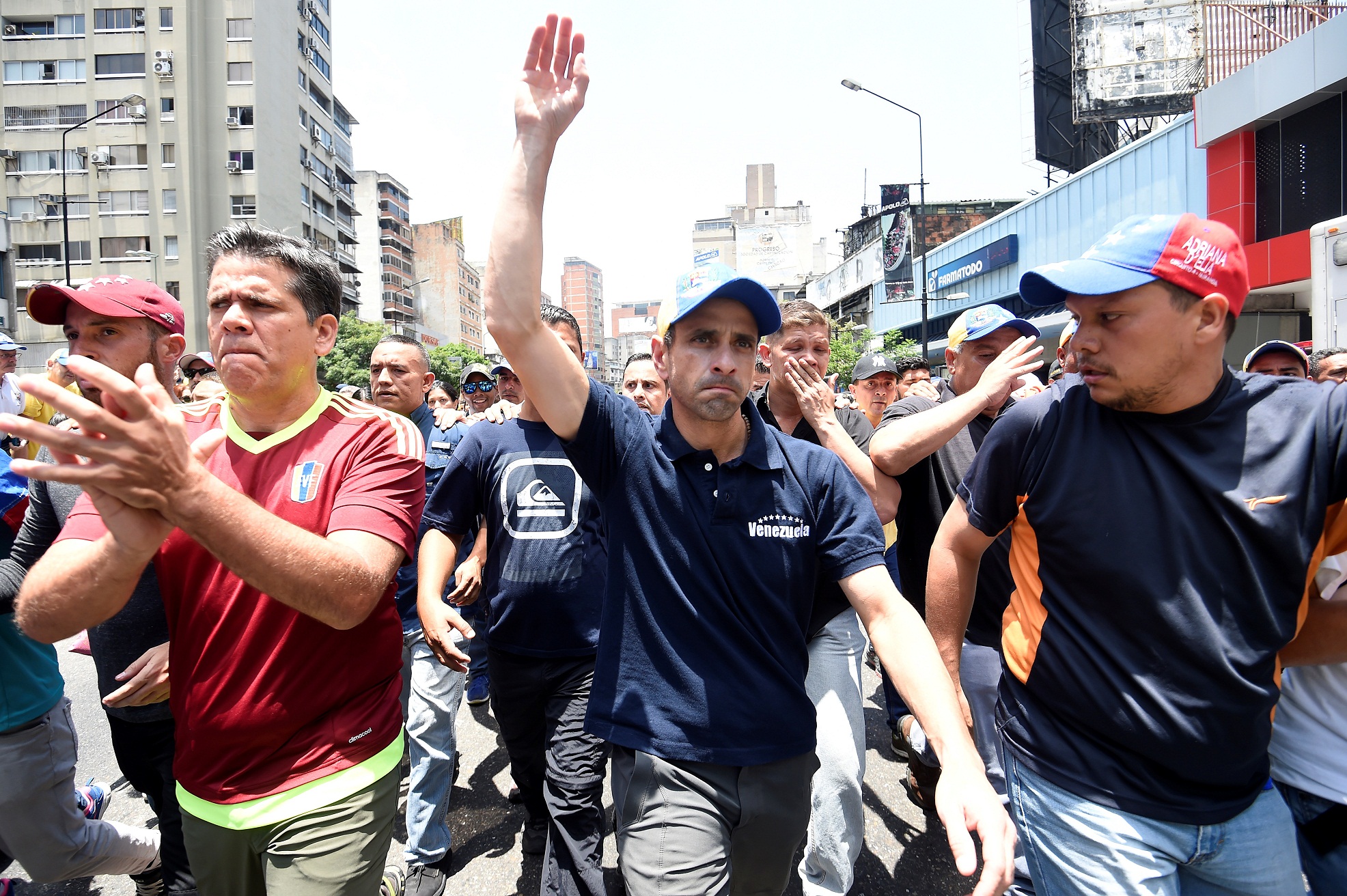 Opposition leader Henrique Capriles(C) is seen during a demonstration against Nicolas Maduro's government east of Caracas on April 8, 2017.  Venezuelan authorities on Friday banned a top opposition leader from public office for 15 years, the latest move in an increasingly tense power struggle in the crisis-hit country. Henrique Capriles was one of the leaders of mass demonstrations this week against socialist President Nicolas Maduro that led to clashes with police  / AFP PHOTO / JUAN BARRETO