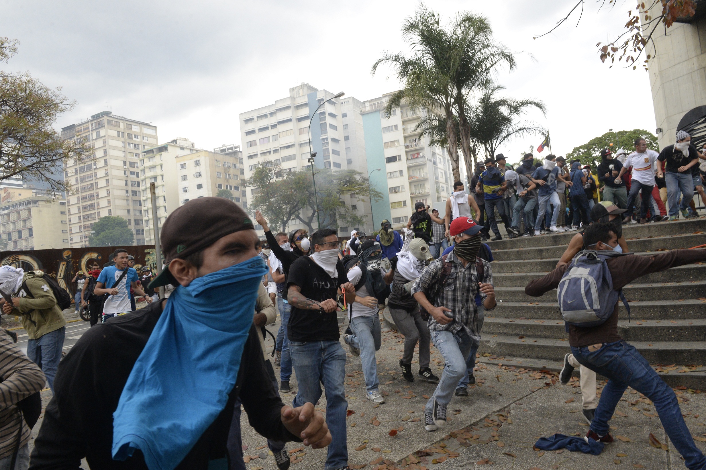 Opposition activists clash with riot police in Caracas on April 10, 2017. Venezuela's political crisis intensified last week when the Supreme Court issued rulings curbing the powers of the opposition-controlled legislature. The court reversed the rulings days later, but the opposition intensified its protests from that moment. / AFP PHOTO / FEDERICO PARRA