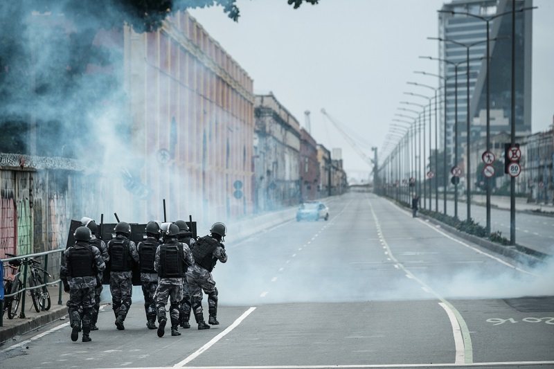 PM militarized police personnel in riot gear fire tear gas at protestors blocking the road before the long-distance bus terminal during the nationwide strike called by unions opposing austerity reforms in Rio de Janeiro, Brazil, on April 28, 2017. Brazilian demonstrators were tear-gassed by riot police Friday during a general strike attempting to shut down transport, schools and banks in protest at economic austerity reforms. / AFP PHOTO / Yasuyoshi Chiba