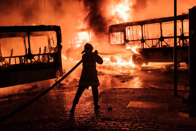 A firefighter tries to put out a burning bus set on fire by protesters during the nationwide strike called by unions opposing austerity reforms in Rio de Janeiro, Brazil, on April 28, 2017. Major transportation networks schools and banks were partially shut down across much of Brazil on Friday in what protesters called a general strike against austerity reforms in Latin America's biggest country. / AFP PHOTO / YASUYOSHI CHIBA