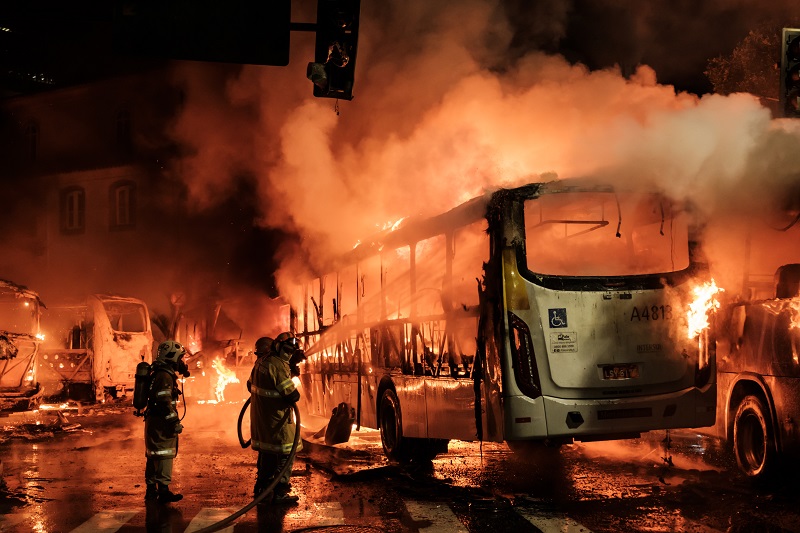Firefighters try to put out a burning bus set on fire by protesters during the nationwide strike called by unions opposing austerity reforms in Rio de Janeiro, Brazil, on April 28, 2017. Major transportation networks schools and banks were partially shut down across much of Brazil on Friday in what protesters called a general strike against austerity reforms in Latin America's biggest country. / AFP PHOTO / YASUYOSHI CHIBA