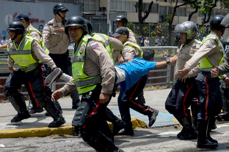 Police carry a demonstrator under arrest during a protest against President Nicolas Maduro's government in Caracas on April 4, 2017.  Activists clashed with police in Venezuela Tuesday as the opposition mobilized against moves to tighten President Nicolas Maduro's grip on power. Protesters hurled stones at riot police who fired tear gas as they blocked the demonstrators from advancing through central Caracas, where pro-government activists were also planning to march. / AFP PHOTO / FEDERICO PARRA