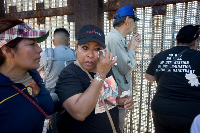 Un miembro de un colectivo de activistas denominado "Caravan Against Fear" (caravana contra el miedo), limpia las lágrimas de sus ojos en el muro fronterizo entre Estados Unidos y México, durante una visita al Parque de la Amistad hoy, domingo 16 de abril de 2017, en San Diego, California. EFE
