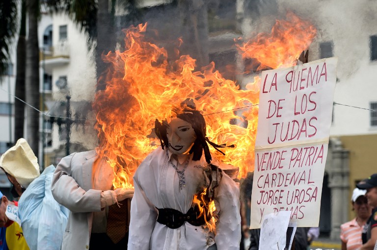 Un muñeco de la exdiputada María Corina Machado, arde en El Silencio, Caracas. AFP PHOTO