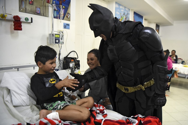 Pablo Valdez (L), 7, who is hospitalized with an infection that prevents him fom walking, is cheered up by Argentine Batman at the 'Sor Maria Ludovica' children's Hospital in La Plata, 60 kilometres south of Buenos Aires, on June 2, 2017. The Argentine Batman has made La Plata children's hospital a target of laughter and treats against pain. / AFP PHOTO / Eitan ABRAMOVICH / TO GO WITH AFP STORY BY PAULA BUSTAMANTE MORE PICTURES IN AFPFORUM