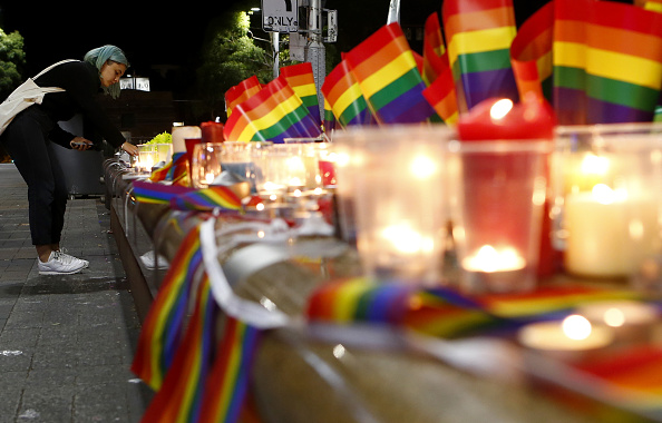 SYDNEY, AUSTRALIA - JUNE 13: A woman lights a candle during a candlelight vigil for the victims of the Pulse Nightclub shooting in Orlando, Florida, at Oxford St on June 13, 2016 in Sydney, Australia. 50 people were killed and 53 injured after a gunman opened fire on people in a gay nightclub in Florida. It is the deadliest mass shooting in US history. (Photo by Daniel Munoz/Getty Images)
