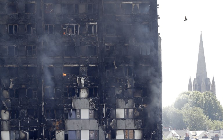 Flames and smoke engulf Grenfell Tower, a residential block on June 14, 2017 in west London.  Shaken survivors of a blaze that ravaged a west London tower block told Wednesday of seeing people trapped or jump to their doom as flames raced towards the building's upper floors and smoke filled the corridors.  / AFP PHOTO / Adrian DENNIS