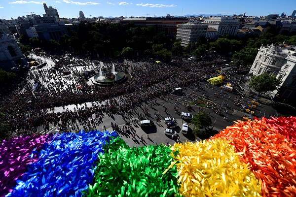 A picture taken on July 1, 2017 shows a general view of Cibeles square from the Cibeles Palace, Madrid's City Hall, with a part of the giant Rainbow banner hanging in foreground,  during the WorldPride 2017 parade in Madrid. Authorities and organisers expect today one to two million people to attend the world's biggest festive demonstration for lesbian, gay, bisexual and transgender rights, in the 3.1-million-strong Spanish capital, which has become a global reference in LGBT openness. / AFP PHOTO / PIERRE-PHILIPPE MARCOU