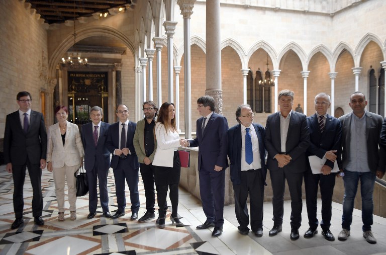 Catalan president Carles Puigdemont (5R) shakes hands with the president of the Independent Commission for Mediation, Dialogue and Conciliation, Maria Eugenia Gay (6R) before holding a meeting at the Catalan Government 'Generalitat' headquarters in Barcelona on October 6, 2017. The Catalan regional government has said it could declare independence next week. It claims voters backed the move in a referendum vote outlawed by Madrid. The political standoff has dragged Spain into its worst political crisis in decades. Catalonia accounts for a fifth of Spain's economy. / AFP PHOTO / LLUIS GENE