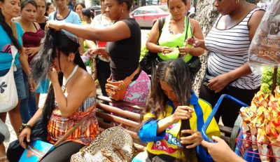 En pleno parque Santander, las mujeres cortan el cabello de sus clientes. Entre 7 y 8 mechones son retirados de sus cabezas